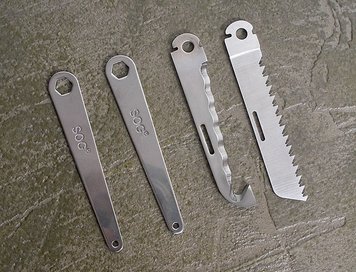 Saw blade, serrated line cutter, and two wrenches  